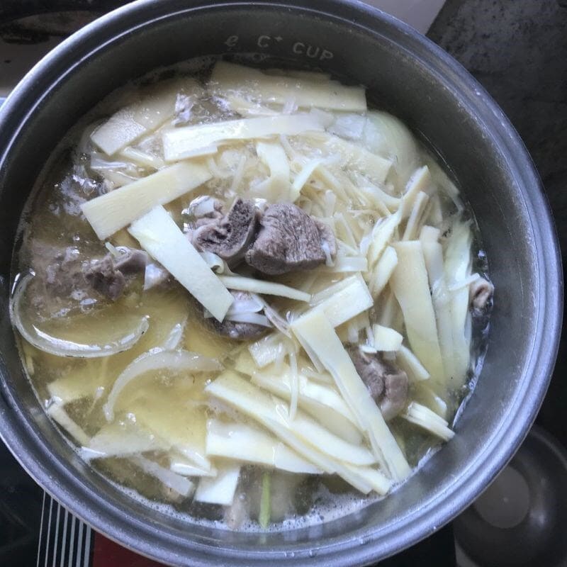 Nấu thịt vịt và măng trên bếp để ngấm đều gia vị